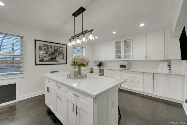 a kitchen that has a lot of white cabinets and wooden floor
