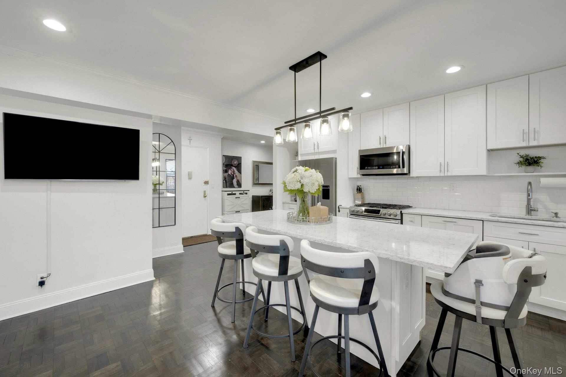 609 Palmer Road, Unit 2J Yonkers, NY 10701 - Photo 4 of 23 a kitchen with stainless steel appliances a dining table chairs microwave and sink