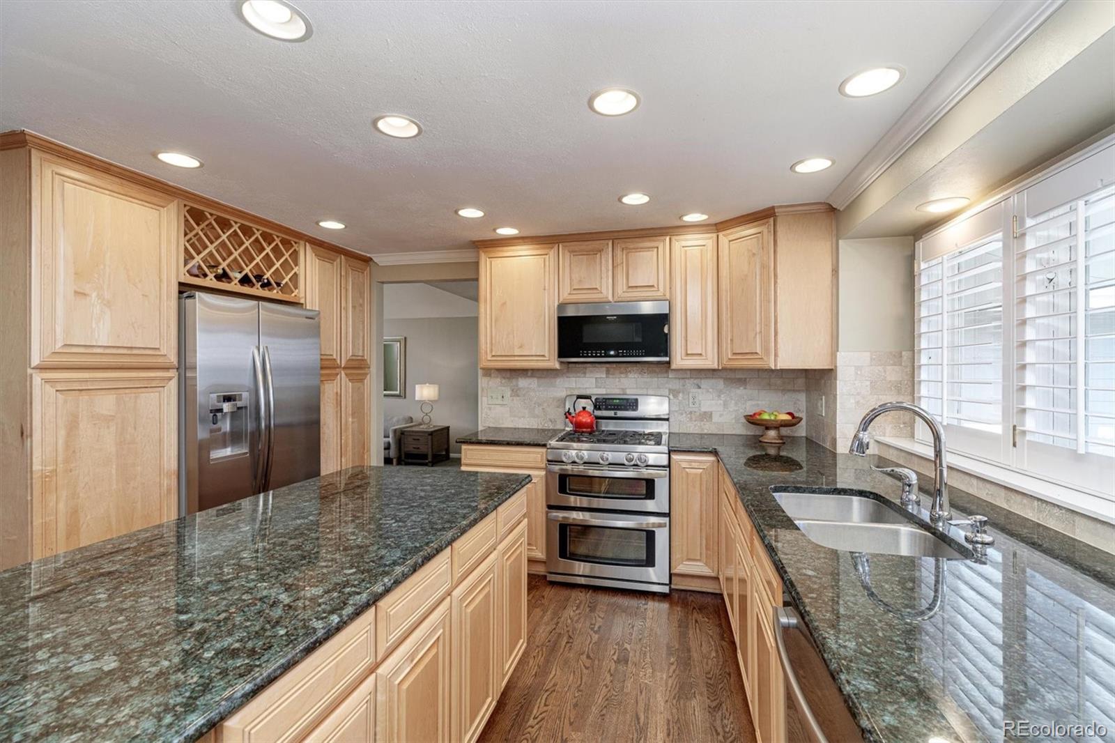 6145 South Eudora Way Centennial, CO 80121 - Photo 11 of 33 a kitchen with stainless steel appliances granite countertop a sink stove and refrigerator