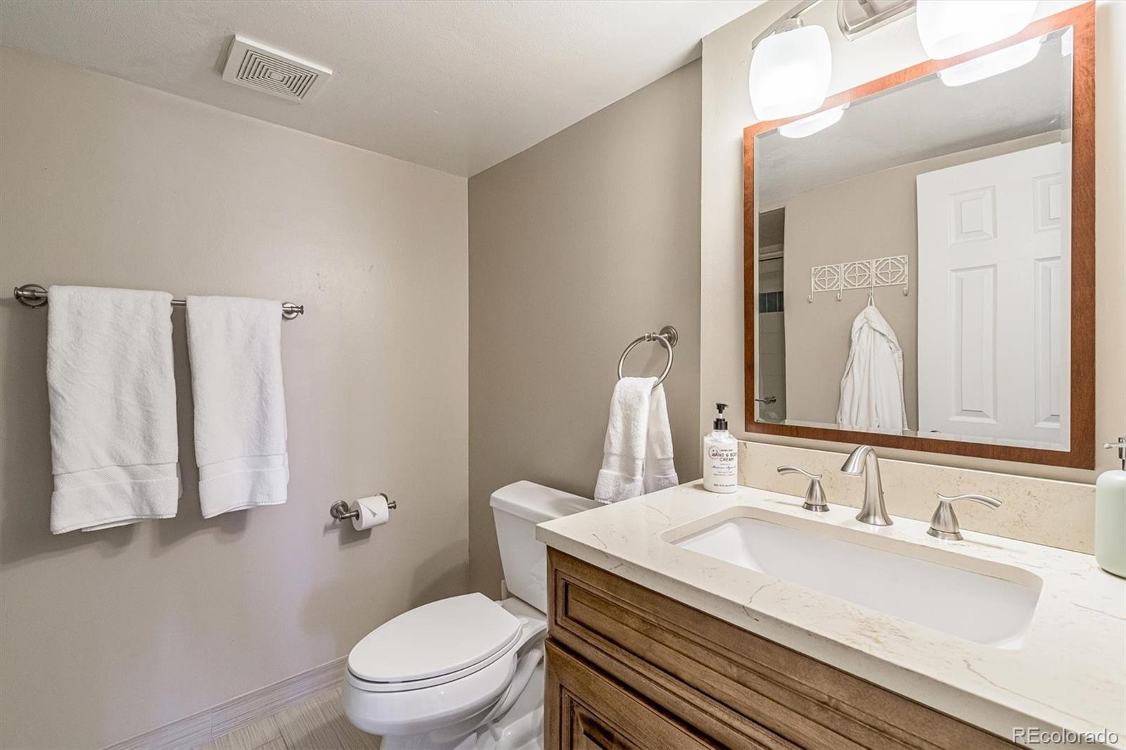 6145 South Eudora Way Centennial, CO 80121 - Photo 27 of 33 a bathroom with a toilet sink and mirror