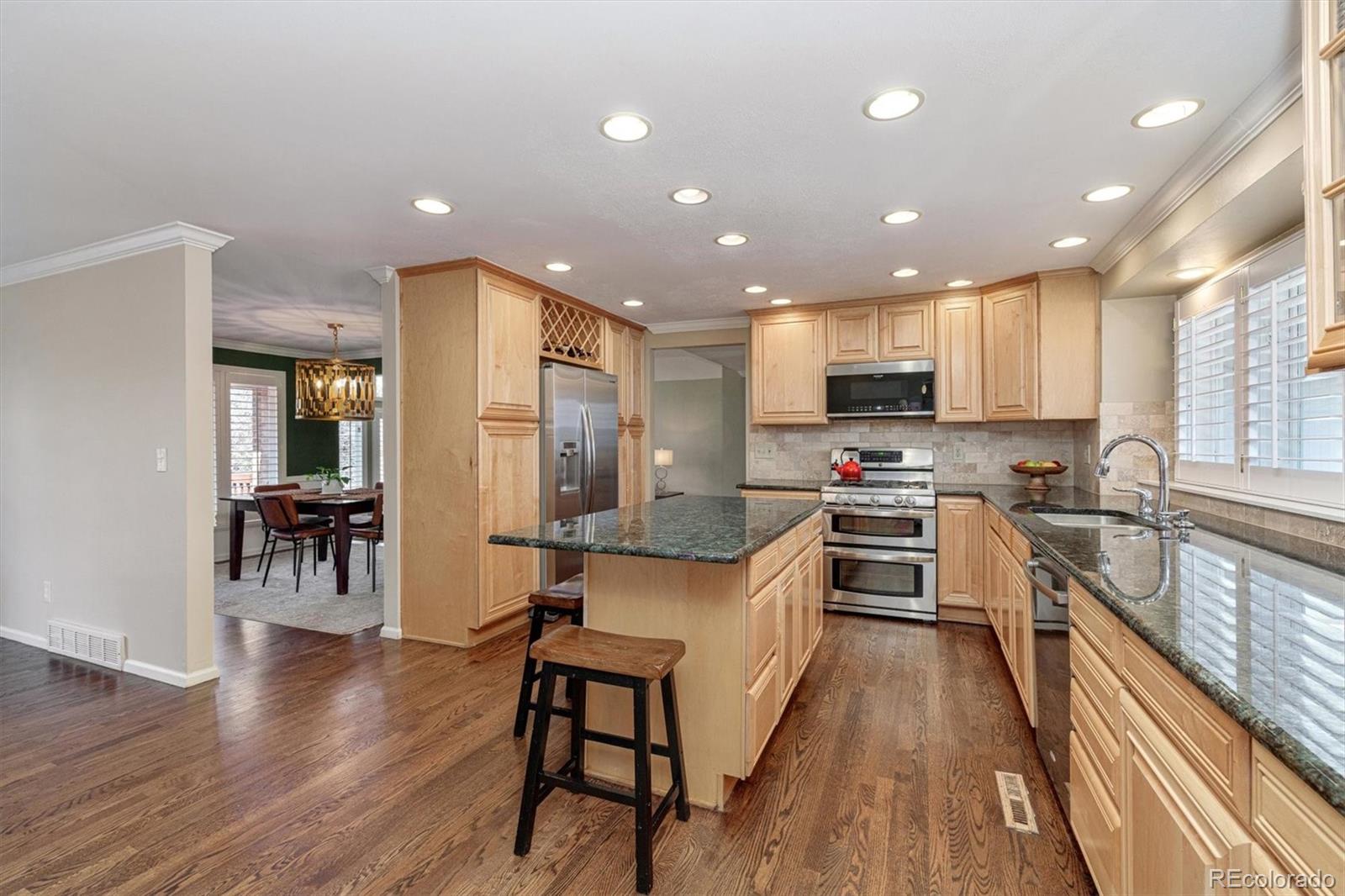 6145 South Eudora Way Centennial, CO 80121 - Photo 10 of 33 a kitchen with stainless steel appliances granite countertop a refrigerator stove microwave and cabinets