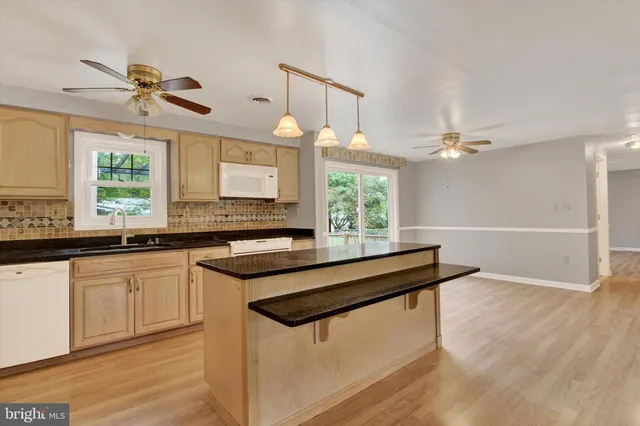 a kitchen with granite countertop a sink cabinets and window