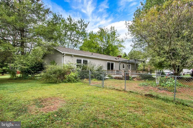 a view of a house with backyard and a tree