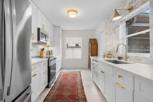 a kitchen with cabinets oven and a sink