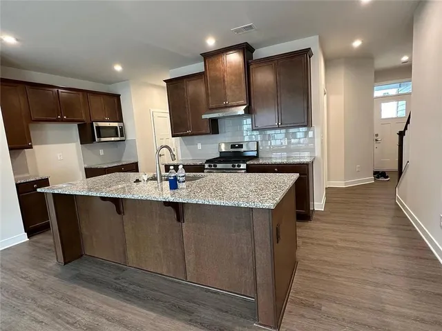 a kitchen with stainless steel appliances granite countertop a sink stove and refrigerator