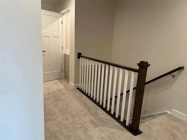 a view of a hallway with wooden floor and staircase