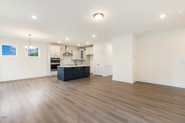 a view of kitchen with kitchen island stainless steel appliances wooden cabinets and window