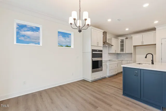 a kitchen with stainless steel appliances granite countertop a sink cabinets and wooden floor