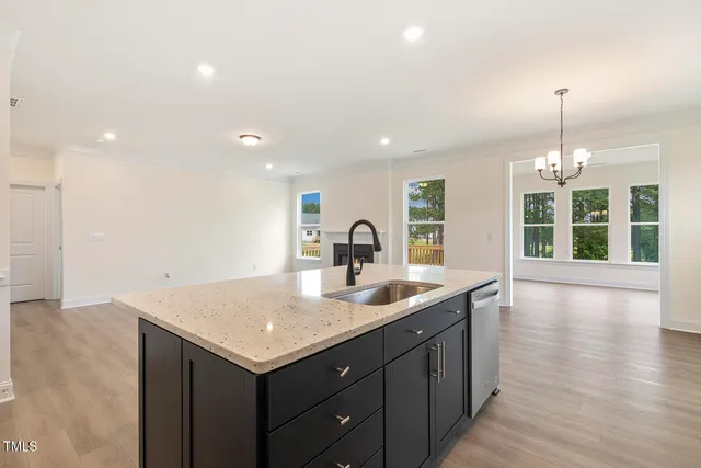 a kitchen with a sink a window and wooden floor