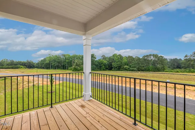 a view of balcony with wooden floor & fence