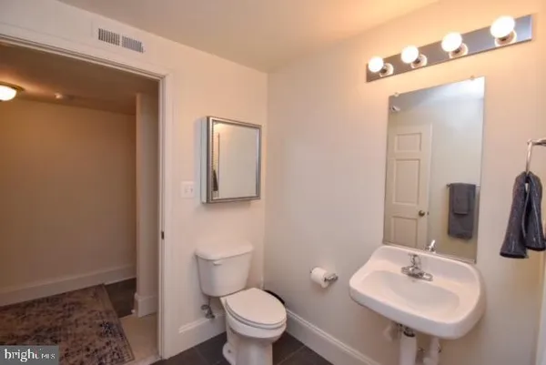 a bathroom with a sink toilet and mirror
