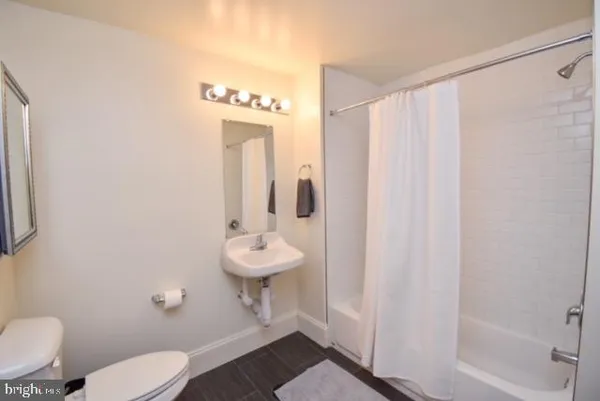 a bathroom with a shower a toilet and a sink