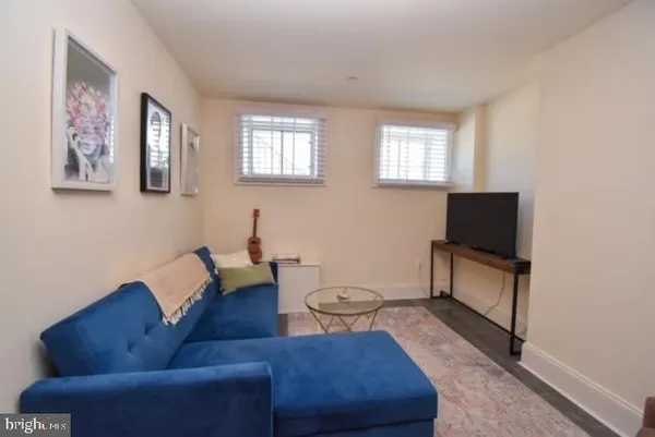 a living room with furniture a rug and a window