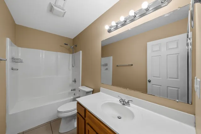 a bathroom with a sink a toilet a mirror and shower