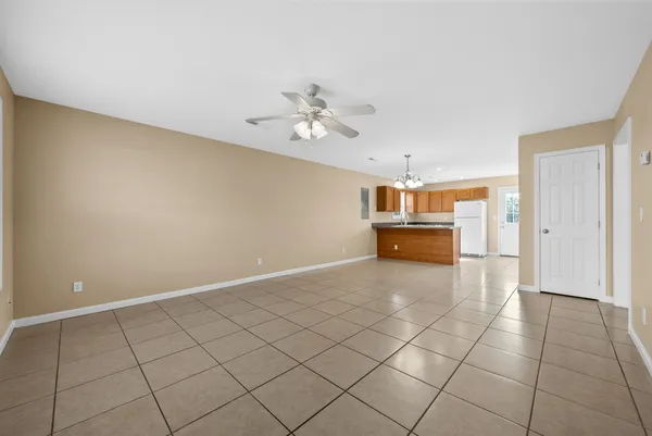 a big room with chandelier fan and windows