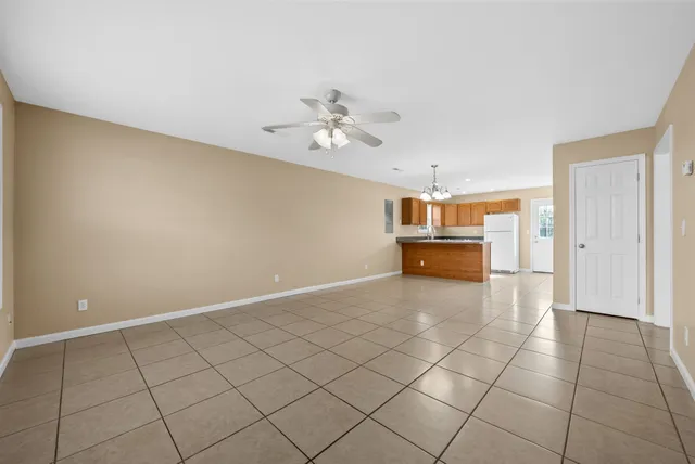 a big room with chandelier fan and windows