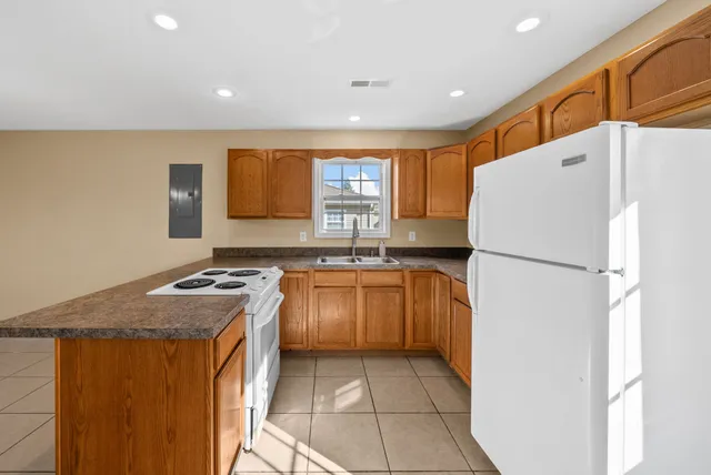 a kitchen with granite countertop a refrigerator and a stove