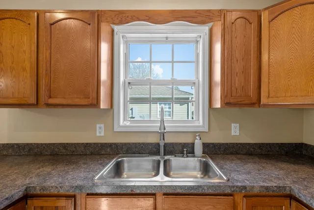 a kitchen with granite countertop white cabinets and sink