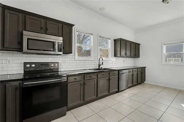 a kitchen with stainless steel appliances granite countertop a stove microwave and sink