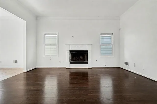 an empty room with wooden floor and fireplace