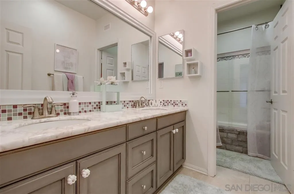 17628 Alva Road San Diego, CA 92127 - Photo 20 of 25 a bathroom with a sink double vanity and a shower