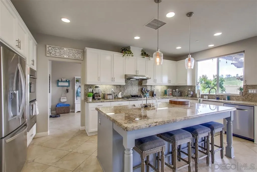17628 Alva Road San Diego, CA 92127 - Photo 10 of 25 a large kitchen with stainless steel appliances granite countertop a stove and a refrigerator