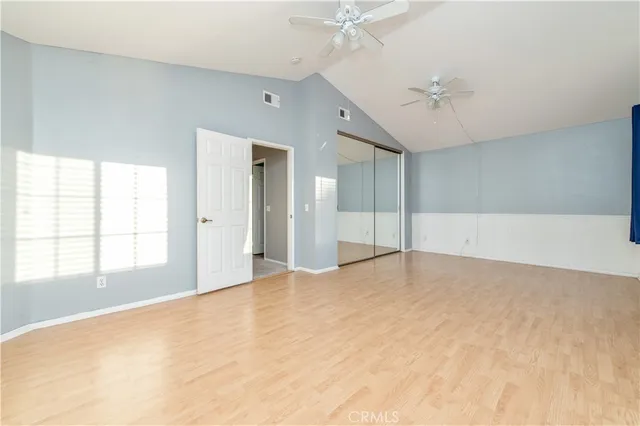 an empty room with fan and windows