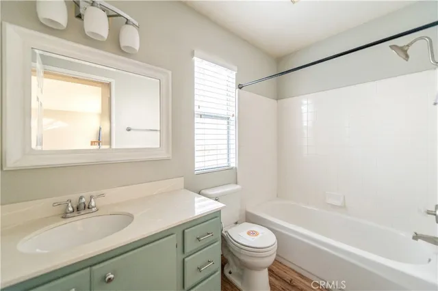 a bathroom with a granite countertop sink toilet a mirror and a bathtub