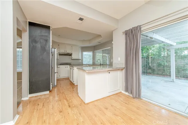 a view of kitchen with kitchen island wooden floor and refrigerator