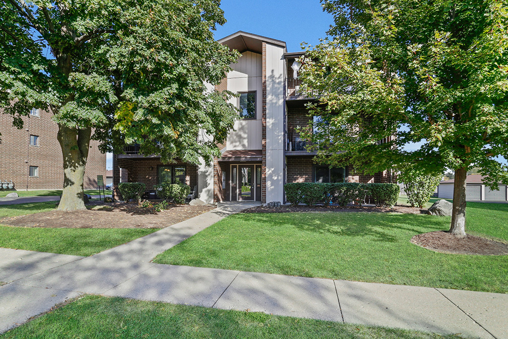 1233 Chalet Road, Unit 101 Naperville, IL 60563 - Photo 1 of 17 a front view of a house with a garden and trees
