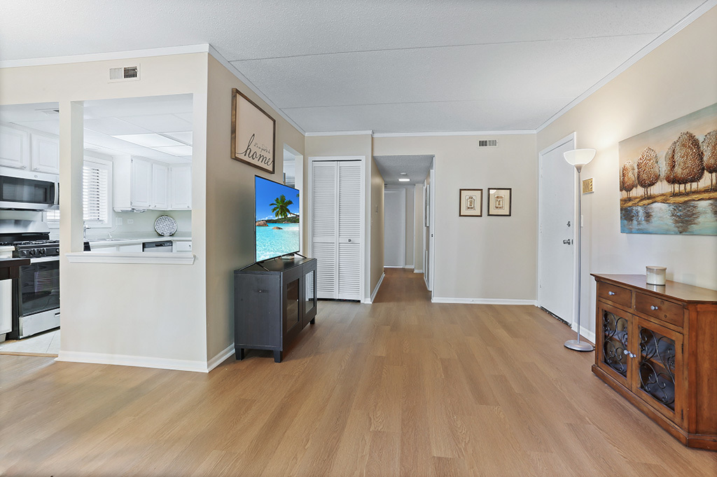 1233 Chalet Road, Unit 101 Naperville, IL 60563 - Photo 7 of 17 a view of a living room kitchen with furniture and a flat screen tv
