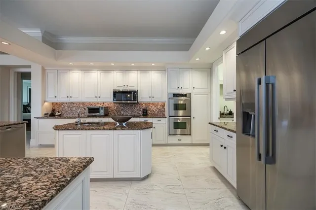 a kitchen with stainless steel appliances granite countertop a refrigerator and a stove