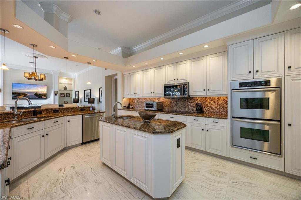 13700 Pondview Circle Naples, FL 34119 - Photo 14 of 49 Kitchen with ornamental molding, recessed lighting, white cabinets, appliances with stainless steel finishes, and light marble finish flooring