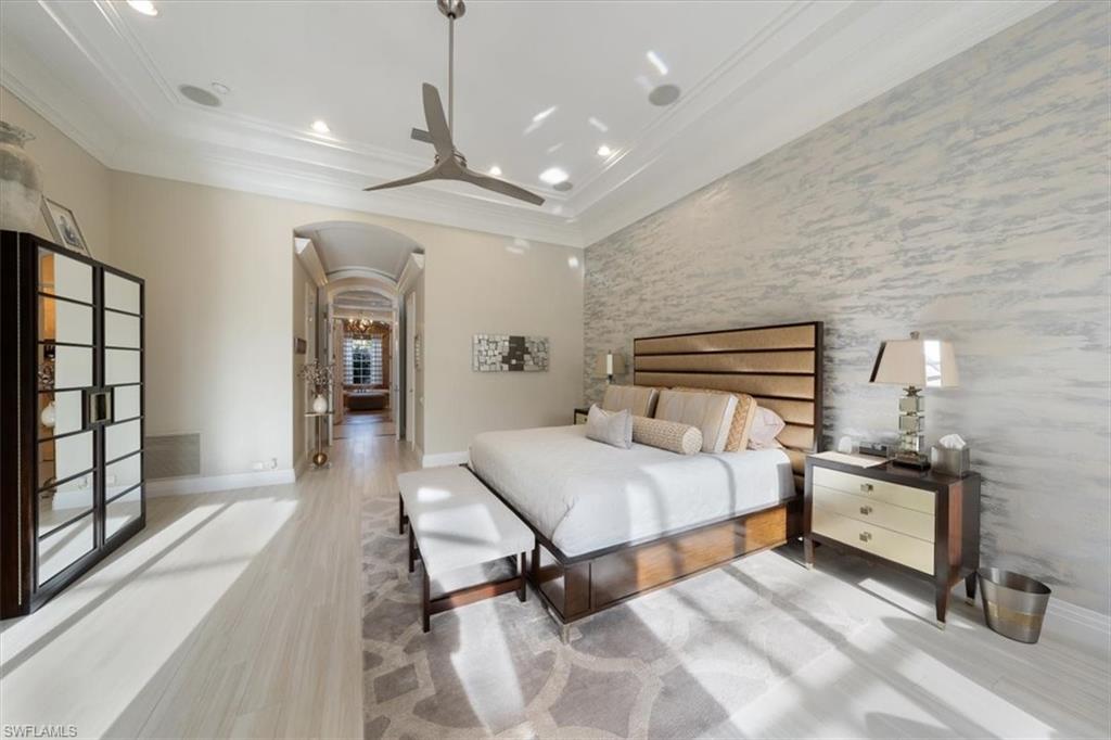 13700 Pondview Circle Naples, FL 34119 - Photo 18 of 49 Bedroom with an accent wall, arched walkways, light wood-style floors, a ceiling fan, and recessed lighting