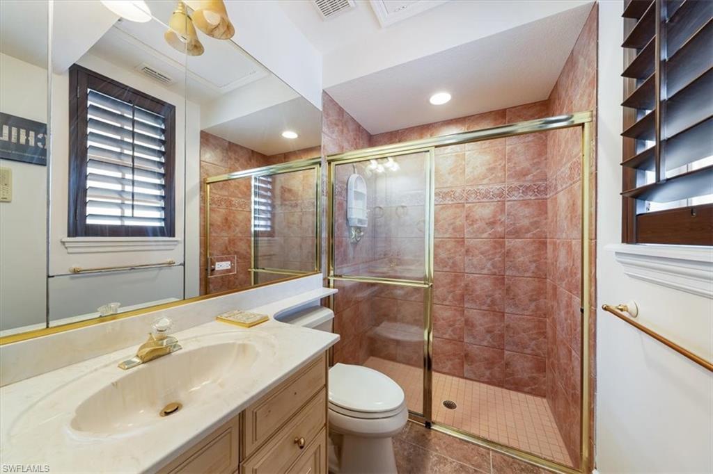 13700 Pondview Circle Naples, FL 34119 - Photo 29 of 49 Full bath with vanity, a stall shower, and dark tile patterned flooring