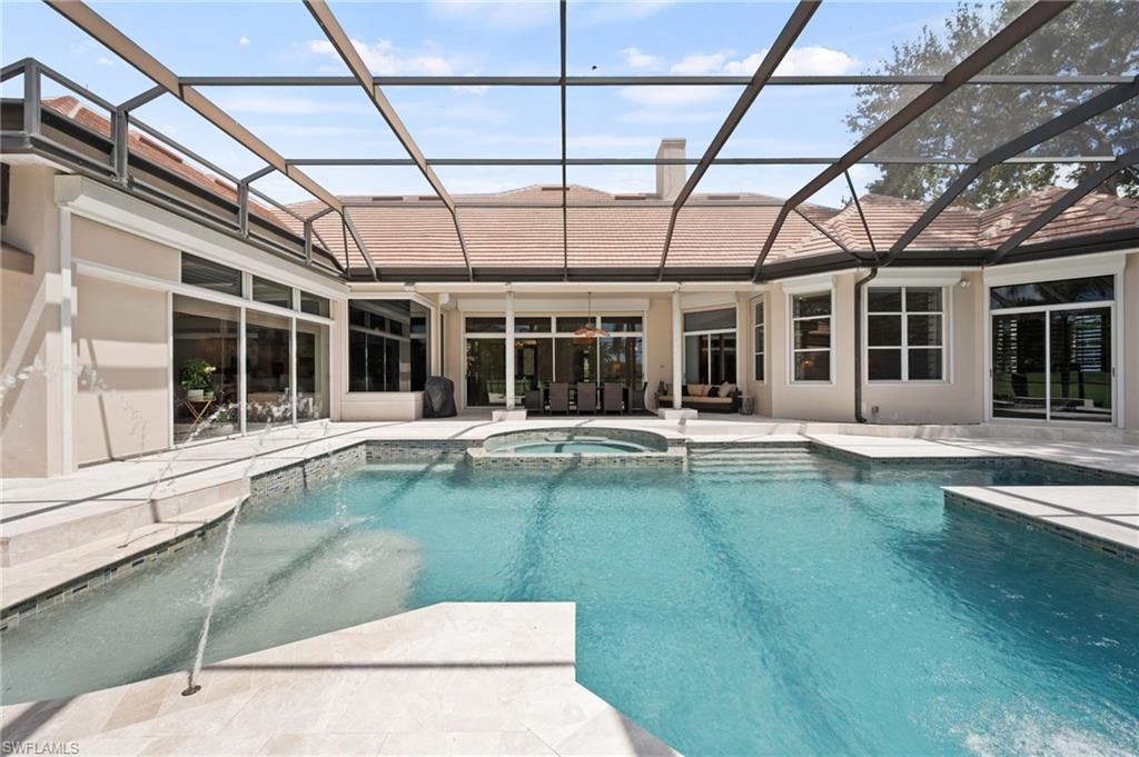 13700 Pondview Circle Naples, FL 34119 - Photo 33 of 49 View of pool with glass enclosure, a sunroom, a pool with connected hot tub, and a patio