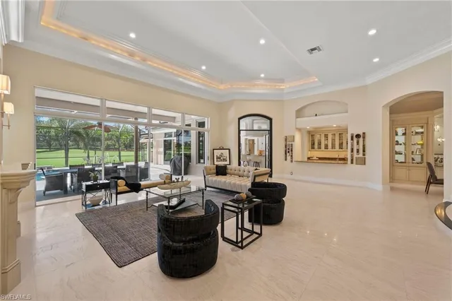 a living room with furniture large windows and a table
