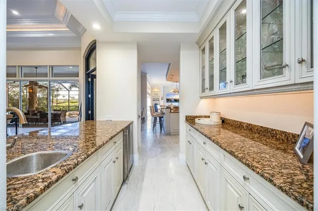 a large kitchen with granite countertop a sink and a wooden floor