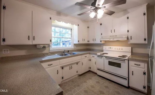 a kitchen with stainless steel appliances granite countertop a sink a stove and a refrigerator