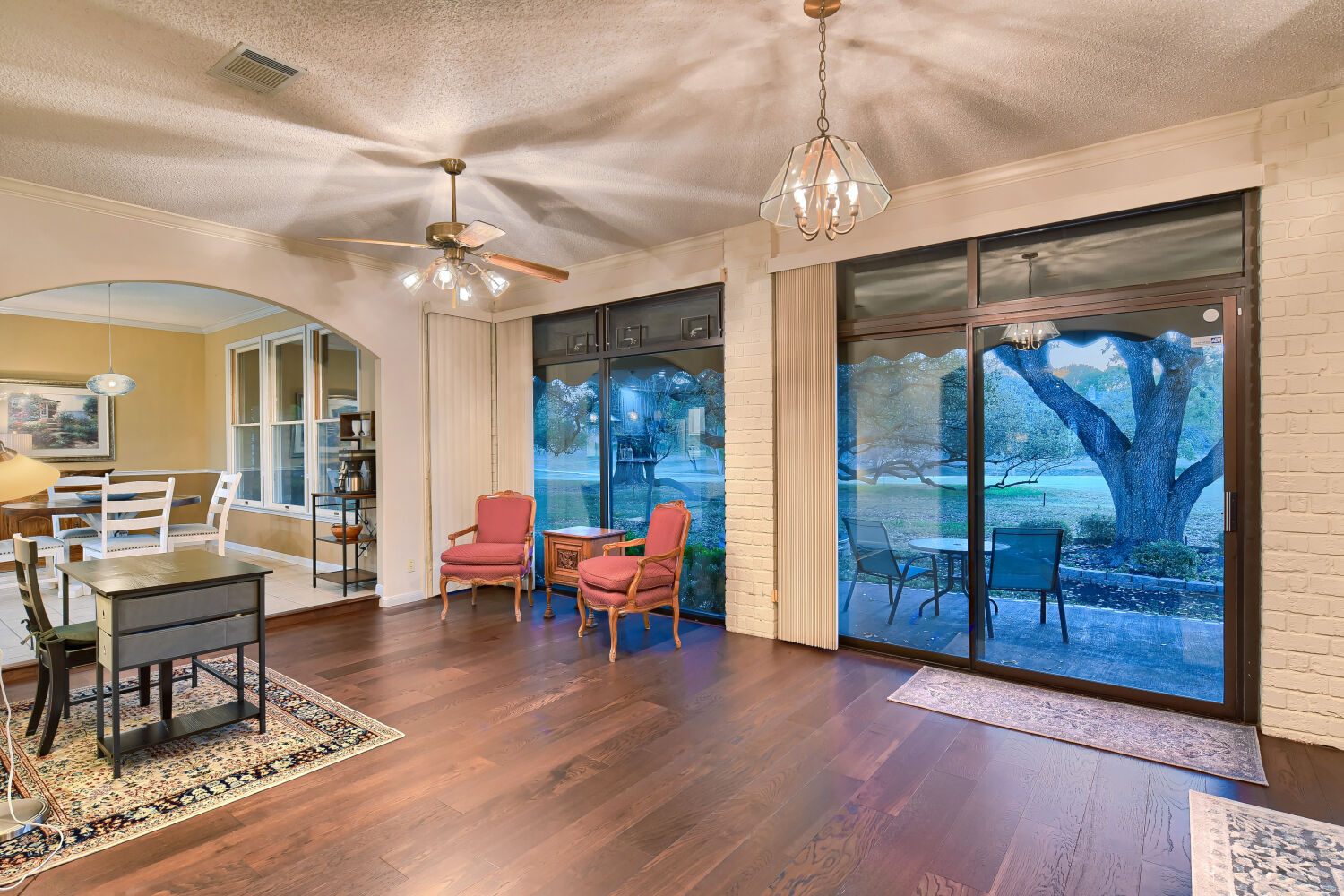10904 Legends Lane Austin, TX 78747 - Photo 16 of 36 a dining room with wooden floor a chandelier a glass table and chairs