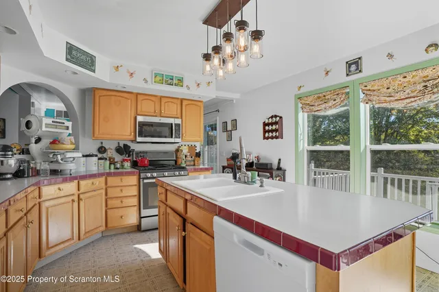 a kitchen with stainless steel appliances granite countertop a stove a sink dishwasher and cabinets with wooden floor
