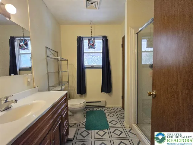 a bathroom with a sink toilet vanity and mirror