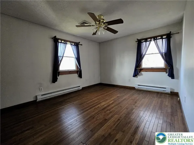 a bedroom with a bed and a flat tv screen on dresser