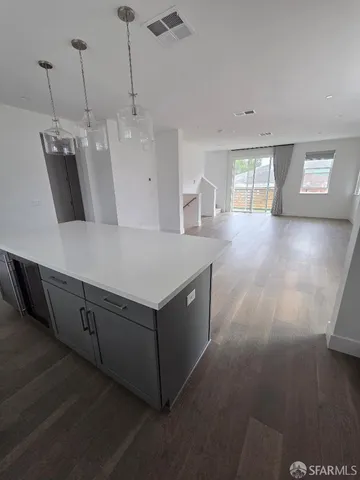 a kitchen with a sink and wooden floor