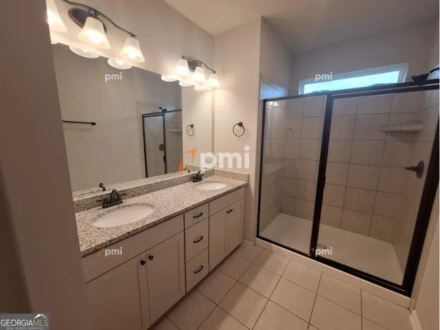 a bathroom with a granite countertop sink a mirror and a shower