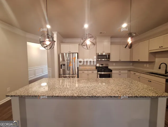 a kitchen with a sink refrigerator and microwave