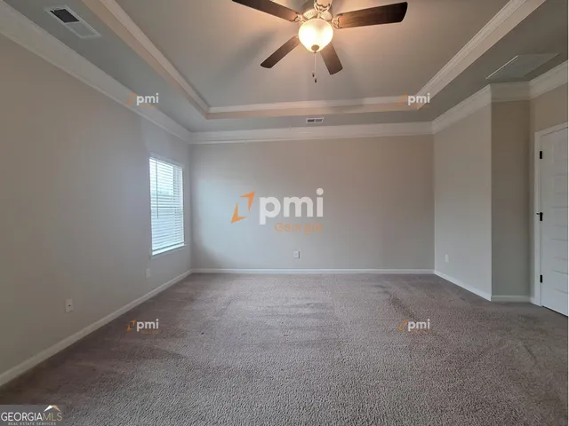 en empty room with windows and fan