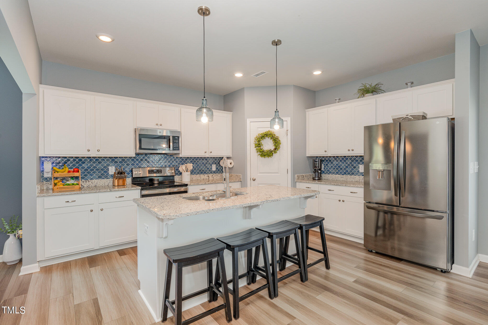 15 New Spring Way Franklinton, NC 27525 - Photo 12 of 41 a kitchen with refrigerator a stove and a wooden floor
