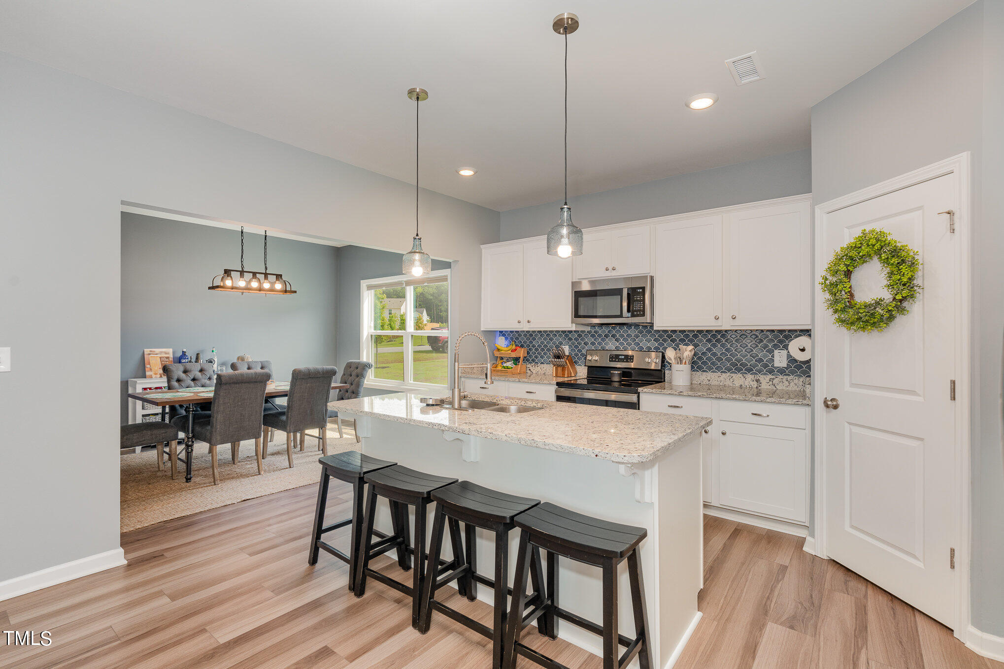 15 New Spring Way Franklinton, NC 27525 - Photo 13 of 41 a kitchen with a dining table chairs refrigerator and microwave