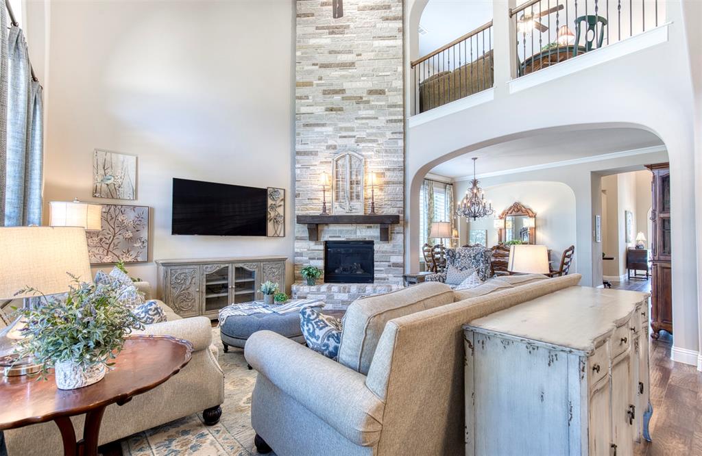 7760 Hackamore Street Frisco, TX 75036 - Photo 8 of 40 Soaring ceilings & a floor-to-ceiling stone gas fireplace give an elevated look.